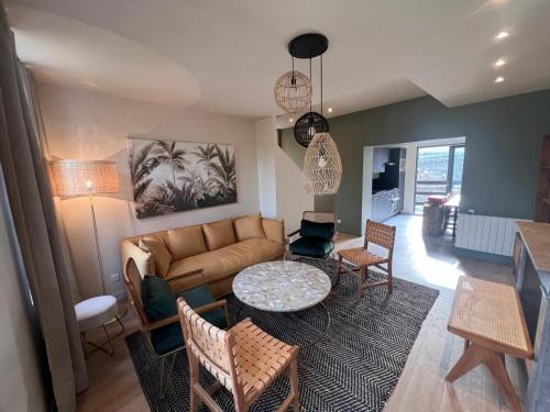 a living room with a couch and a table at Le Clos de St Val 3 in Saint-Valéry-sur-Somme