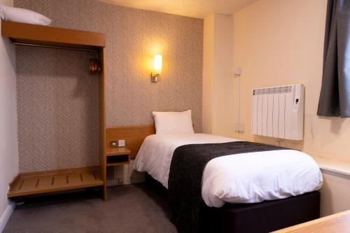 a small room with a bed and a small table at De Trafford Arms by Chef & Brewer Collection in Alderley Edge