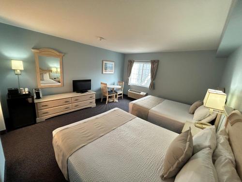 a hotel room with two beds and a mirror at South Beach Resort Hotel in Marblehead