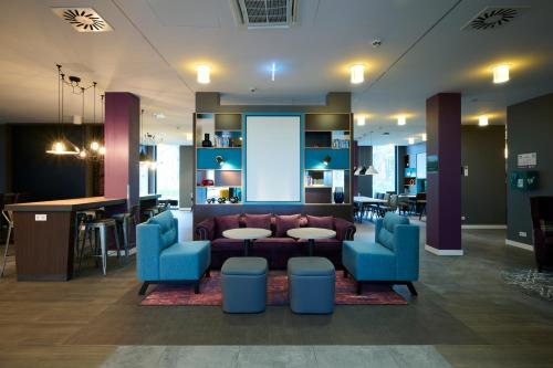 a lobby with a couch and chairs and a bar at Premier Inn Freiburg City Nord in Freiburg im Breisgau