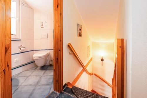 a small bathroom with a toilet and a staircase at Ferienhaus Seestern - Bade- & Saunawelt täglich inklusive in Baabe