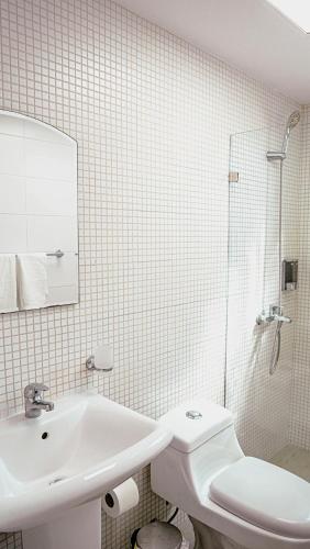 a white bathroom with a sink and a toilet at Ankara Residence in Santo Domingo