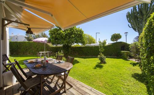 a table and chairs under an umbrella on a patio at C12 - Sunshine Apartment in Luz in Luz