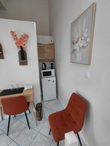 a kitchen with a table and chairs and a stove at chambre d 'hôtes les Orchidées in Perpignan