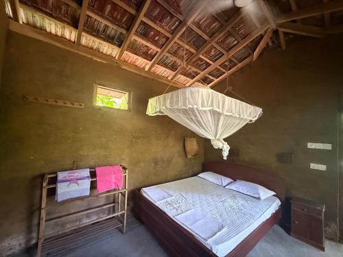 a bedroom with a bed and an umbrella at The Mud House in Talalla South