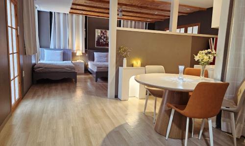 a living room with a table and a bedroom at Picasso Guesthouse in Mokpo