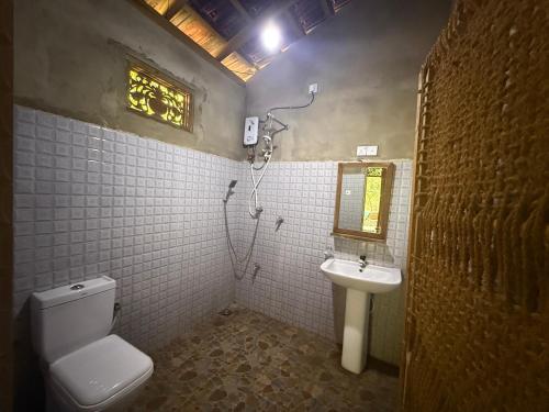 a bathroom with a toilet and a sink at The Mud House in Talalla South
