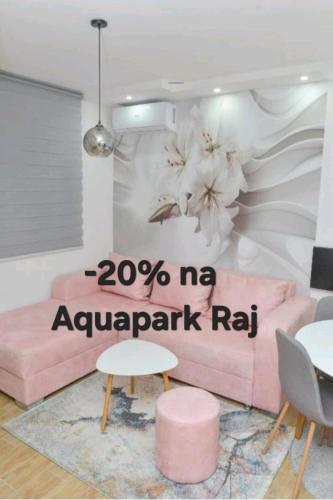 a room with a pink couch with a me avalaprab ra sign at Apartmani Martenovic in Vrnjačka Banja