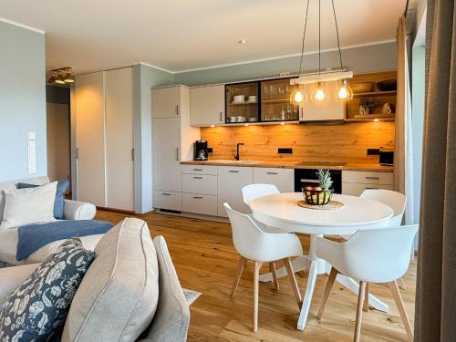 a kitchen and a living room with a table and chairs at Ferienwohnung Gartenidyll am Dümmer See in Lembruch