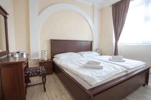 a bedroom with a bed and a desk and a window at Mattes Restaurant & Pension in Držovice