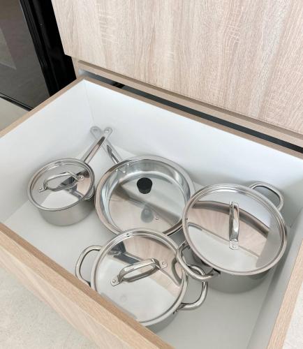 four metal pots and pans sitting in a drawer at Mananero III in Sosúa