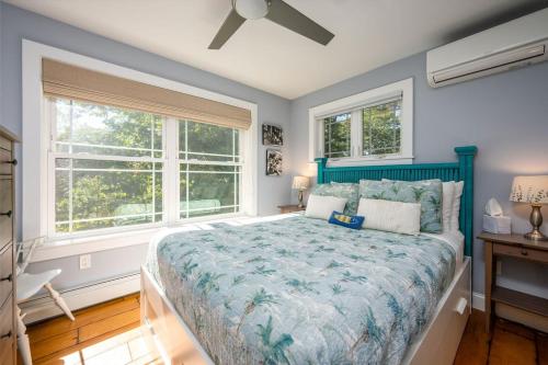 a bedroom with a large bed and two windows at Colonels Quarters in Kennebunk