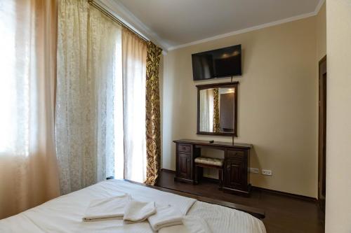 a bedroom with a bed and a mirror and a window at HARMONY Apart in Truskavets