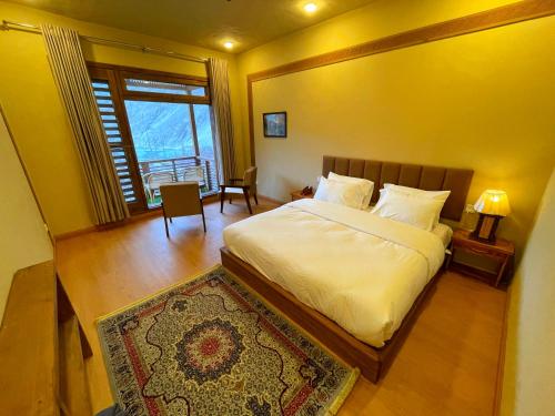 a bedroom with a large bed and a window at Diwan-e-Hunza Resort in Gulmit