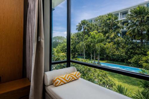 a room with a window with a view of a pool at Suite Aura 1BR PoolsGyms Shuttle to Nai Harn in Rawai Beach