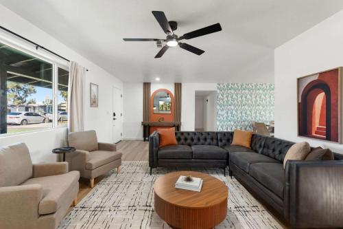 a living room with a couch and a ceiling fan at Mesa Oasis - Pool - Game Room - Fire Pit in Mesa