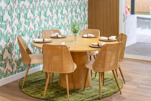 a wooden table with rattan chairs in a room at Mesa Oasis - Pool - Game Room - Fire Pit in Mesa