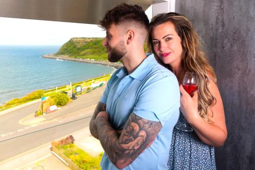 a man and a woman holding a glass of wine at The Boat House Luxury Apartments Scarborough in Scarborough