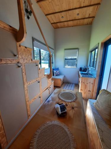 a living room with a couch and a table at Mountain view Bespoke tiny home in Plettenberg Bay