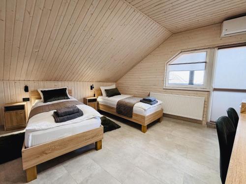 two beds in a room with a large window at Old Friend Guest House in Berehove