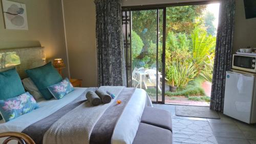 a bedroom with a bed with two stuffed animals on it at King's Hill Guest House in Hilton