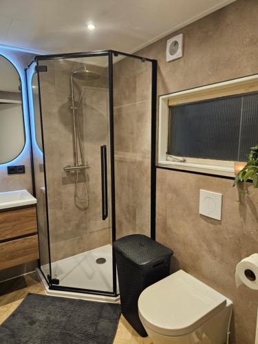 a bathroom with a shower and a toilet at Madeliefje - Familie camping in Raalte in Raalte