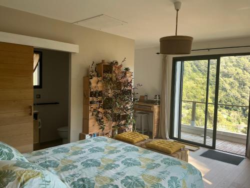 a bedroom with a bed and a large window at Chambres d hôtes les Romarins in Cantaron