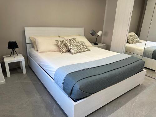 a bedroom with a large white bed with pillows at Casa di WR in Imperia