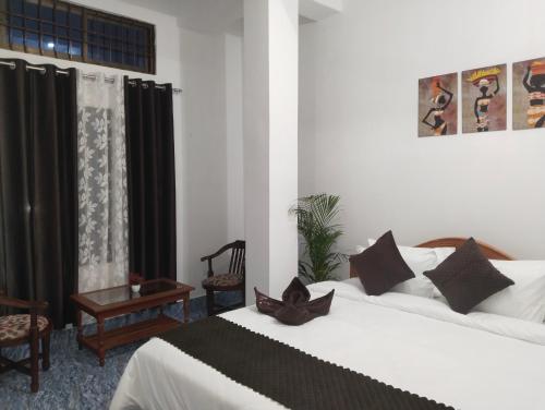 a hotel room with two beds and a window at Bhanu Homestay in Nowgong