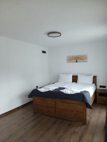 sypialnia z łóżkiem, białymi ścianami i drewnianą podłogą w obiekcie Devin River w mieście Devín