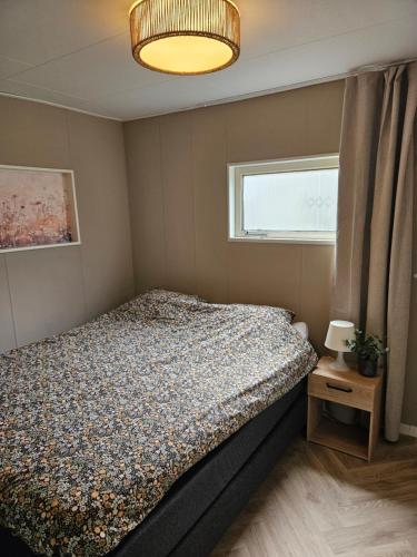 a small bedroom with a bed and a window at Madeliefje - Familie camping in Raalte in Raalte