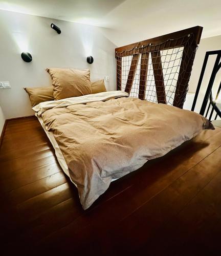 a bedroom with a large bed with a wooden headboard at Refugium Lodziense II - Quiet luxury in the center of Lodz in Łódź