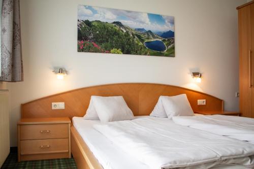 a bedroom with two beds and a painting on the wall at Holzmannhof in Flachau