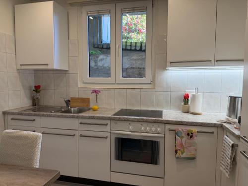 a kitchen with white cabinets and a sink at Molino Vecchio in Ronco sopra Ascona