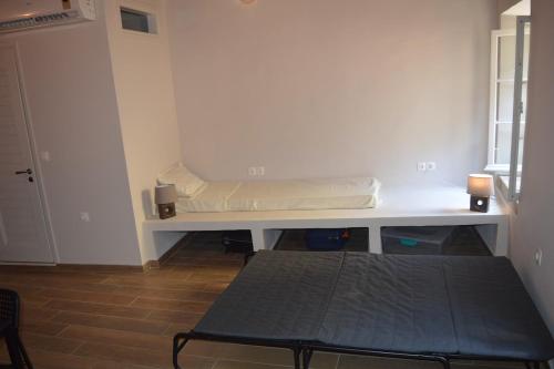 a room with a bench with a mattress on it at Lemonia apartment Old Town in Corfu