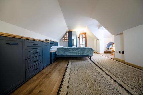 a bedroom with blue cabinets and a bed on a wooden floor at Villa Royal in Craiova