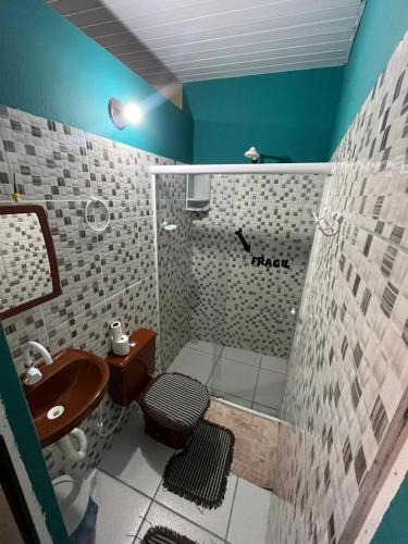 a bathroom with a sink and a toilet and a shower at Hostel Caiçara in Santo Amaro