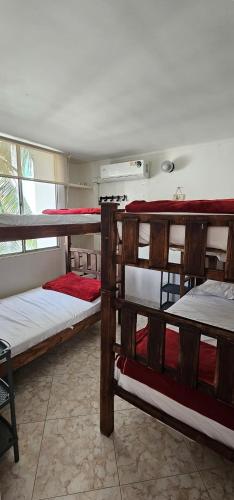 a room with four bunk beds in a room at Tu Refugio Tropical Cerca al Mar in Santa Marta