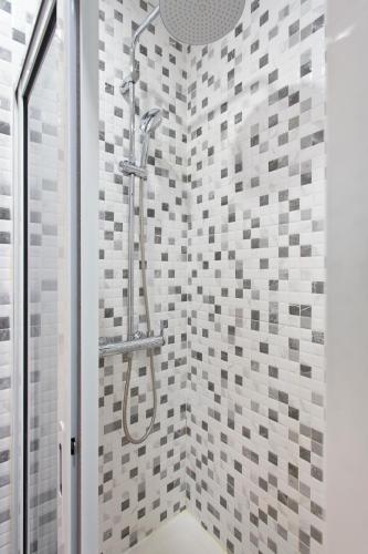 a shower in a bathroom with gray and white tiles at Braganca Oporto in Porto