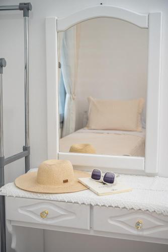 a hat and sunglasses on a dresser with a mirror at Villa Leta in Kokkari