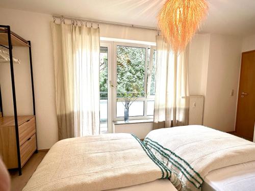 a bedroom with a bed and a large window at Stilvolle 3-Zimmer-Wohnung für business und family bis 6 Personen in Sindelfingen