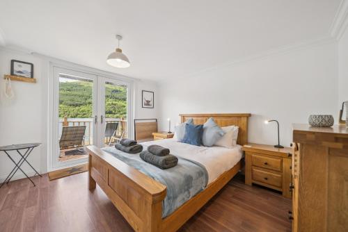 a bedroom with a large bed with towels on it at Cottage on the Loch in Arrochar