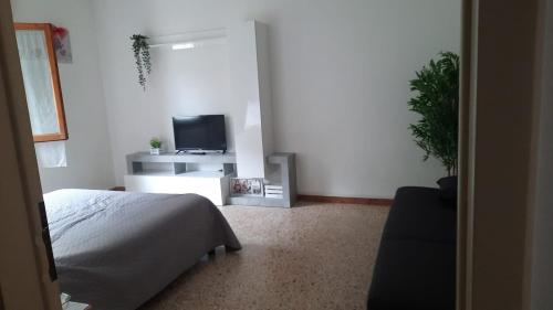 a bedroom with a bed and a flat screen tv at Flat in Chiesina Uzzanese in Chiesina Uzzanese