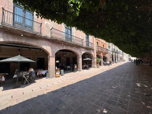 an empty street with tables and chairs and buildings at Centro 19 Hotel in Querétaro
