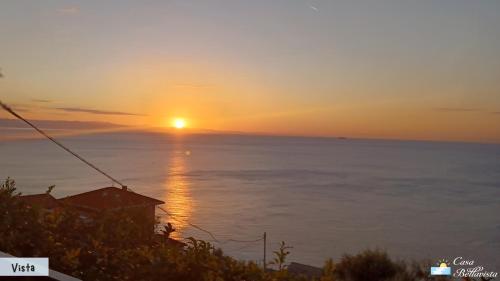 a sunset over the ocean with a house in the foreground at Casa Bellavista in Bergeggi