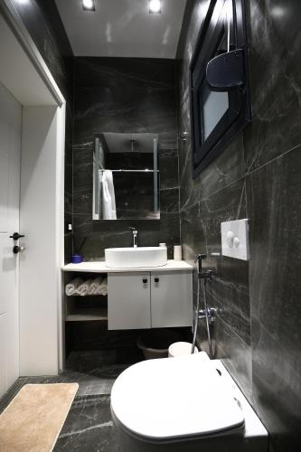 a bathroom with a white toilet and a sink at Julis Villa in Draç