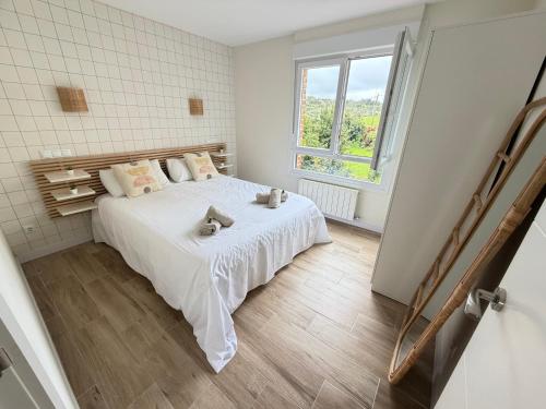 a white bedroom with a bed with two stuffed animals on it at Lively Sopela House by Kima Gestíon in Sopelana