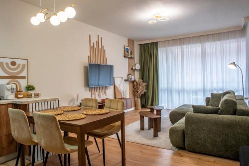 a living room with a table and a couch at Forestline Apartment Sinaia in Sinaia