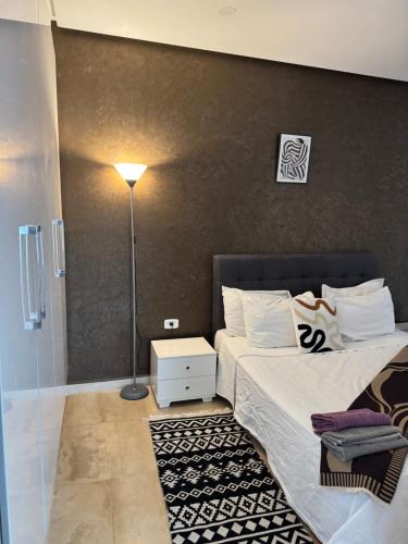 a bedroom with a large bed and a lamp at Le Chill Out in Tunis