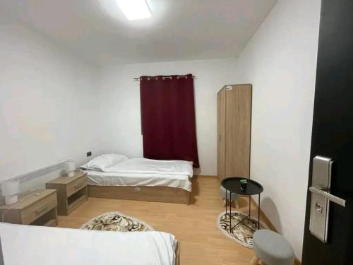 a bedroom with a bed and a red curtain at Camping La Ozan in Petreştii de Jos